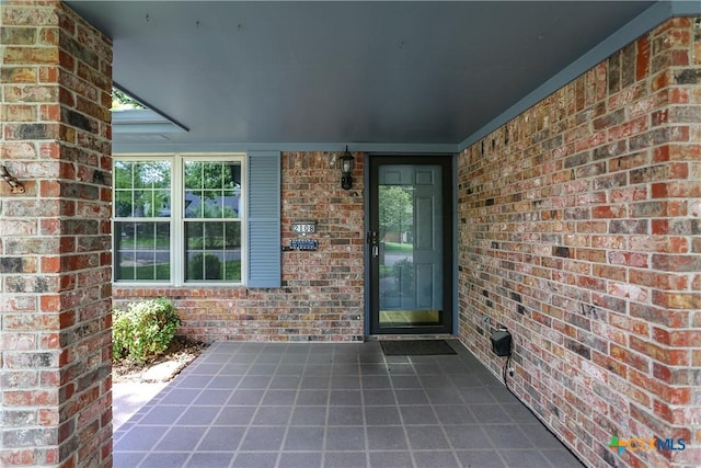 doorway to property featuring brick siding