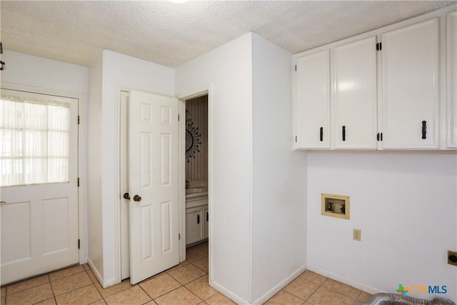 laundry room with cabinet space, washer hookup, electric dryer hookup, baseboards, and light tile patterned flooring