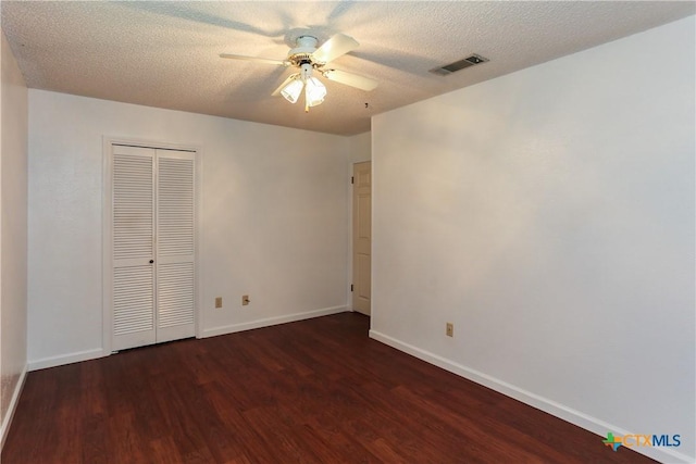 unfurnished bedroom with wood finished floors, baseboards, a closet, a textured ceiling, and ceiling fan