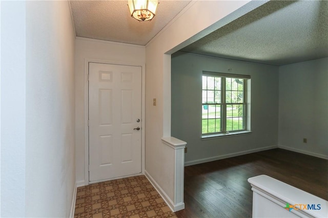 entryway featuring a textured ceiling, baseboards, and wood finished floors