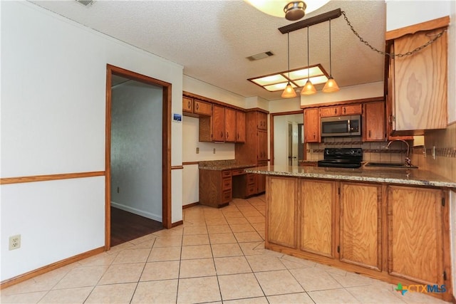 kitchen featuring stainless steel microwave, black range with electric cooktop, a sink, a peninsula, and backsplash
