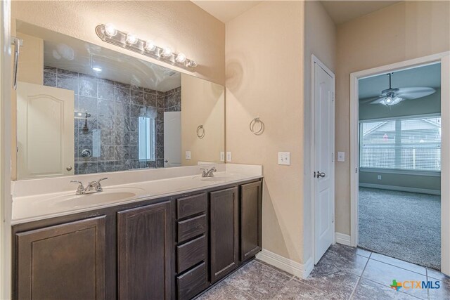 bathroom featuring ceiling fan, tiled shower, vanity, and tile patterned flooring