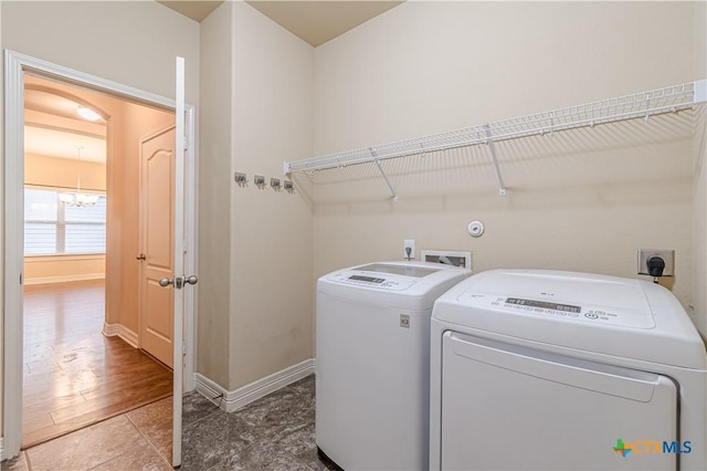 washroom with an inviting chandelier and independent washer and dryer