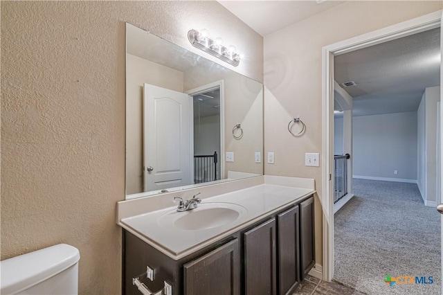 bathroom featuring vanity and toilet