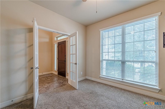 carpeted empty room featuring french doors