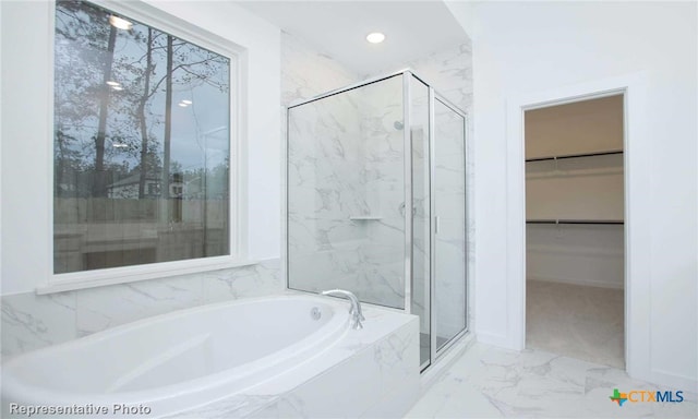 bathroom featuring shower with separate bathtub