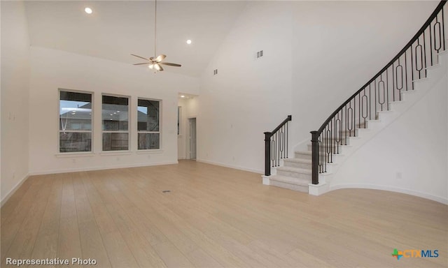 unfurnished living room featuring light hardwood / wood-style flooring, high vaulted ceiling, and ceiling fan