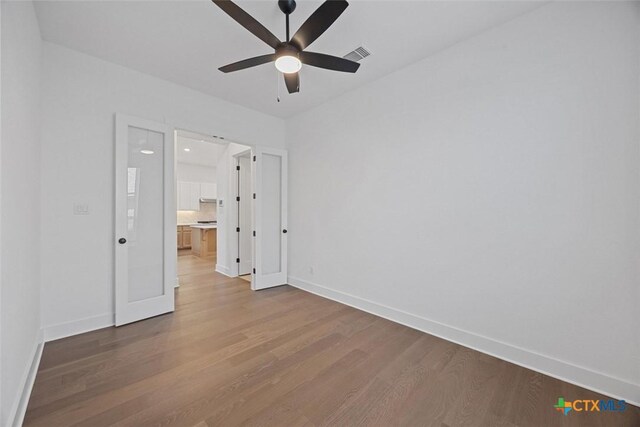 kitchen with backsplash, a center island with sink, sink, light wood-type flooring, and stainless steel appliances