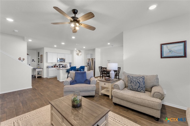 living room featuring ceiling fan and dark hardwood / wood-style floors