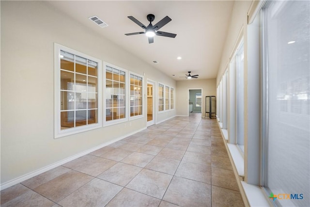 unfurnished sunroom with ceiling fan