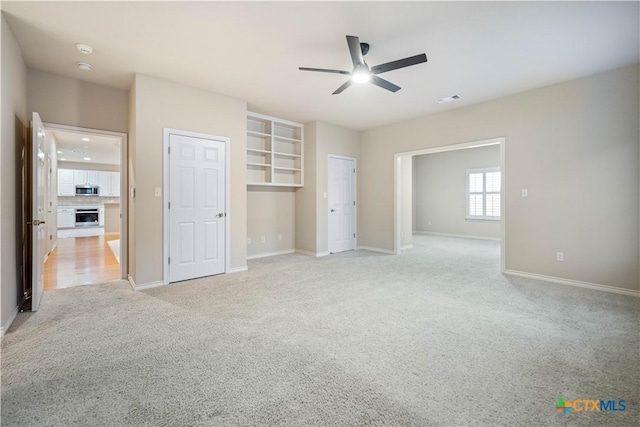 unfurnished bedroom featuring ceiling fan and light carpet