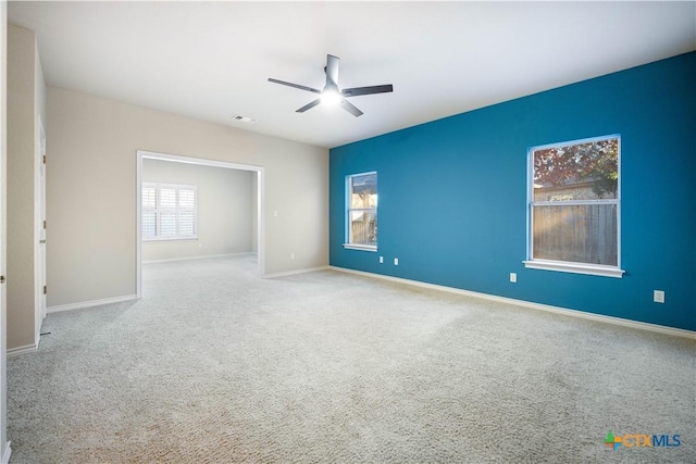 carpeted spare room featuring ceiling fan