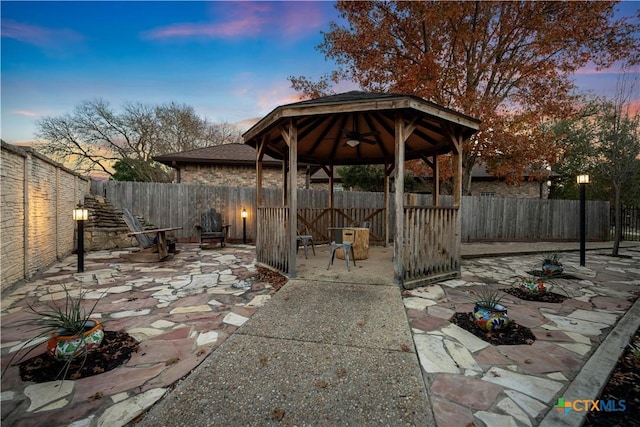 patio terrace at dusk featuring a gazebo