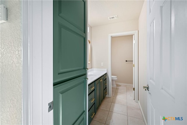 bathroom featuring tile patterned flooring, vanity, and toilet