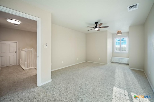 spare room with ceiling fan and light carpet