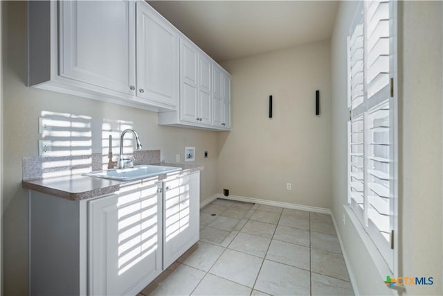 washroom with sink, electric dryer hookup, plenty of natural light, cabinets, and washer hookup