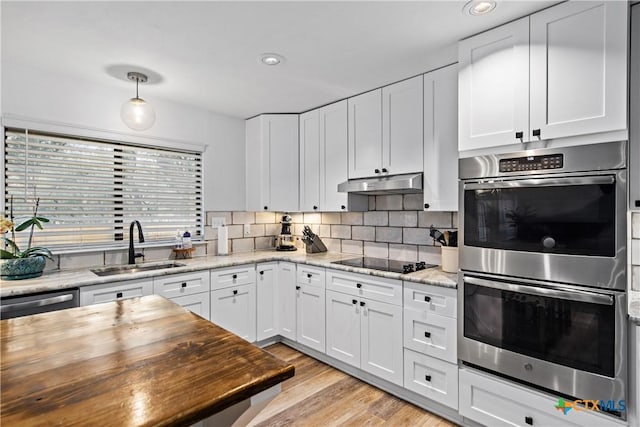 701 W Esparada Dr, Georgetown, TX 78628 - kitchen with stainless steel appliances, a sink, under cabinet range hood, butcher block counters, and recessed lighting
