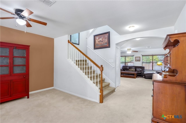 stairs featuring carpet floors and ceiling fan