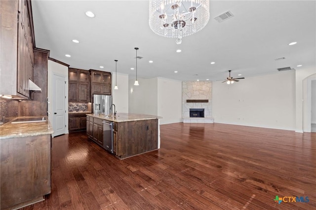 200 Tate Ln, Round Rock, TX 78626 - kitchen with appliances with stainless steel finishes, dark brown cabinets, backsplash, dark wood finished floors, and a ceiling fan