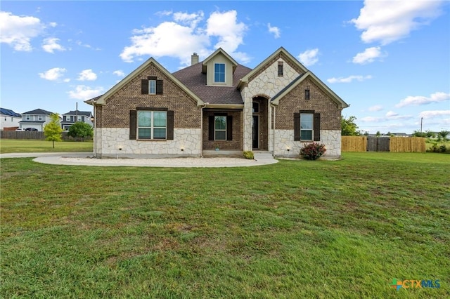 200 Tate Ln, Round Rock, TX 78626 - french country home featuring stone siding, a chimney, roof with shingles, and brick siding