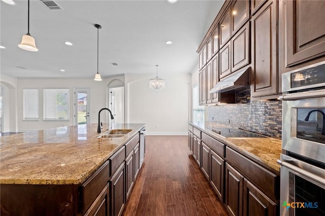 200 Tate Ln, Round Rock, TX 78626 - kitchen with appliances with stainless steel finishes, dark wood finished floors, backsplash, recessed lighting, and arched walkways