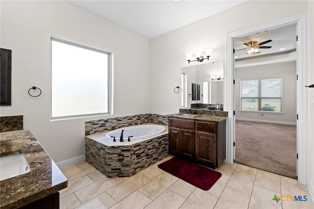200 Tate Ln, Round Rock, TX 78626 - bathroom with two vanities, a garden tub, ceiling fan, and tile patterned floors