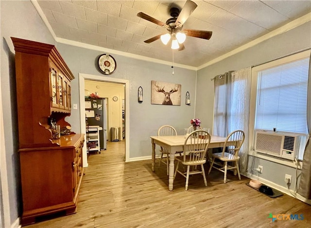 dining space with ornamental molding, light wood-style flooring, baseboards, and a ceiling fan