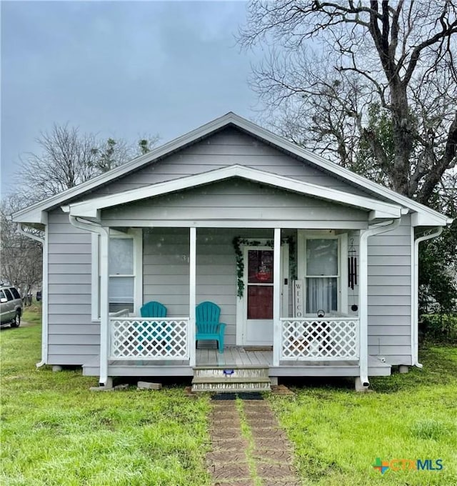 bungalow-style house with covered porch and a front lawn