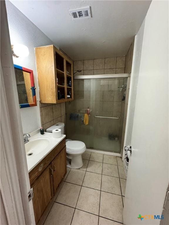 bathroom featuring toilet, tile walls, a shower with shower door, and vanity