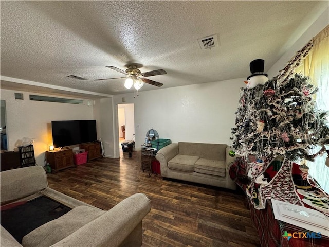 living room with ceiling fan, dark hardwood / wood-style flooring, and a textured ceiling