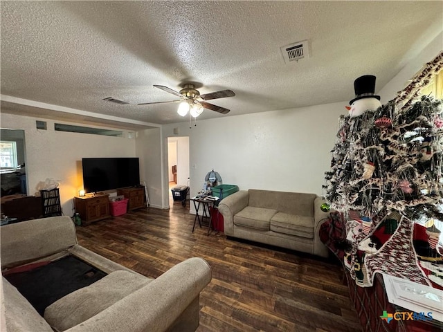 living room with ceiling fan, a textured ceiling, and dark hardwood / wood-style flooring