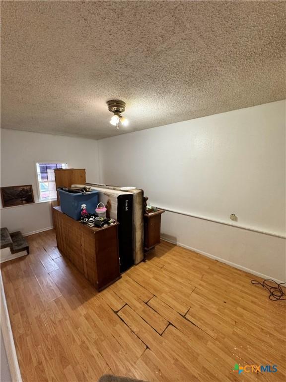 unfurnished office with a textured ceiling and light hardwood / wood-style floors