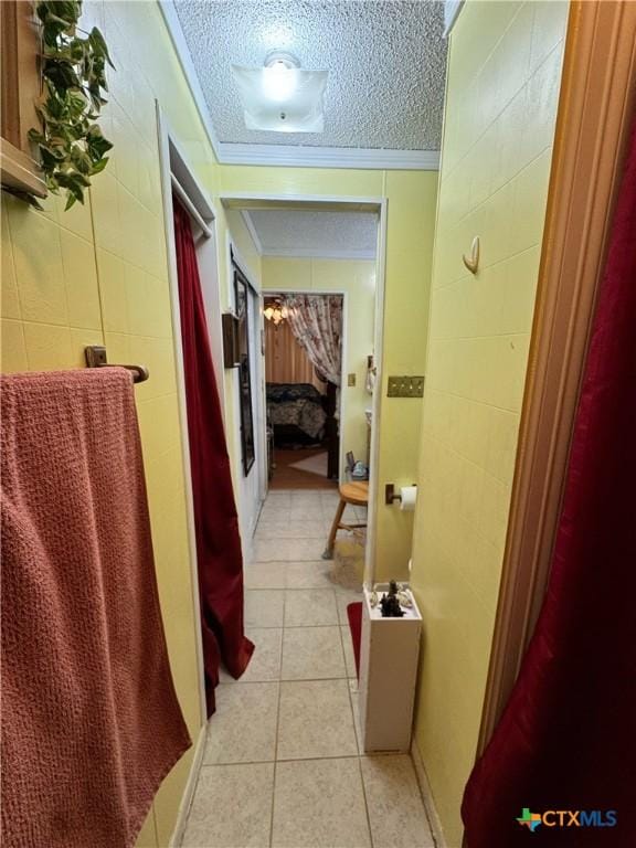 bathroom featuring a textured ceiling, tile patterned floors, and crown molding