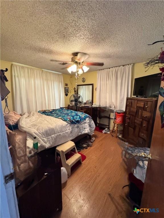 bedroom featuring ceiling fan, a textured ceiling, and hardwood / wood-style flooring