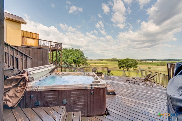 wooden terrace featuring a hot tub and a rural view