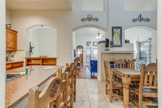 tiled dining room featuring a towering ceiling and ceiling fan