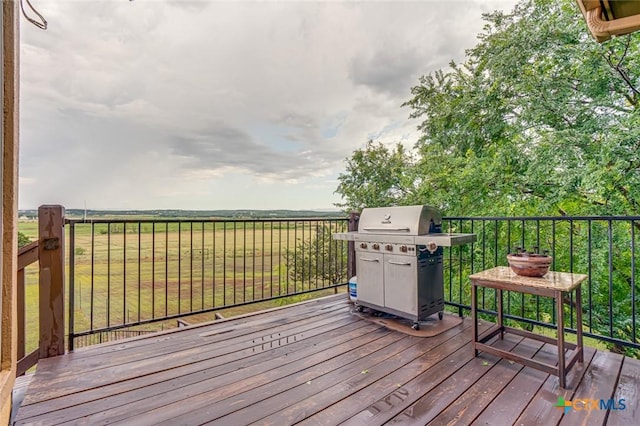 wooden terrace featuring area for grilling and a lawn