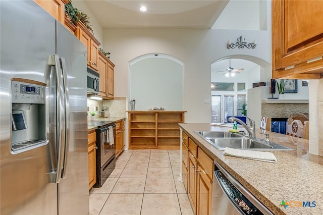 kitchen with appliances with stainless steel finishes, tasteful backsplash, sink, light tile patterned floors, and ceiling fan