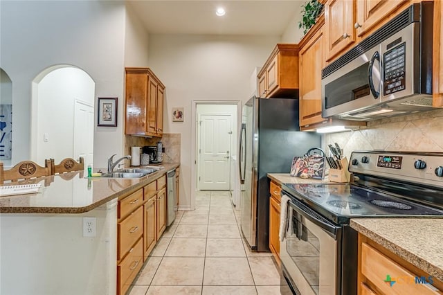 kitchen with stainless steel appliances, tasteful backsplash, sink, and light tile patterned floors