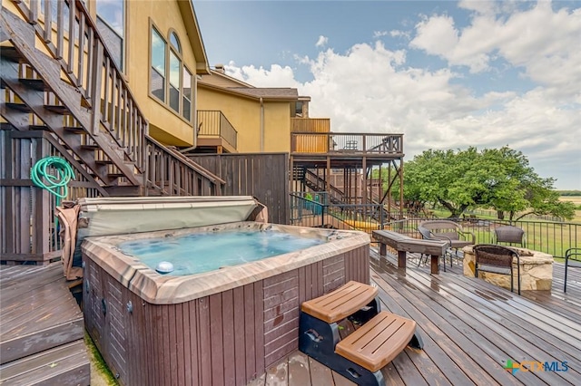 wooden terrace featuring a fire pit and a hot tub