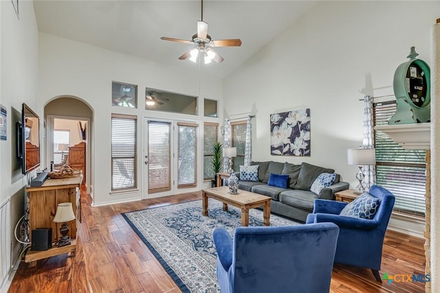 living room with wood-type flooring, ceiling fan, and high vaulted ceiling