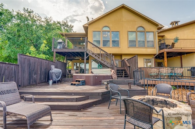 wooden deck with a fire pit and a hot tub