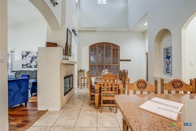 dining area featuring a towering ceiling and light tile patterned floors