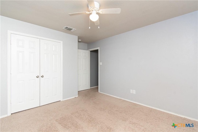 unfurnished bedroom with a closet, ceiling fan, visible vents, baseboards, and carpet floors