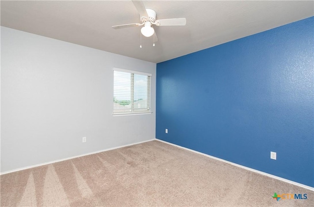 spare room featuring a ceiling fan, carpet flooring, and baseboards