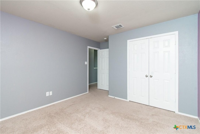 unfurnished bedroom featuring a closet, visible vents, carpet, and baseboards