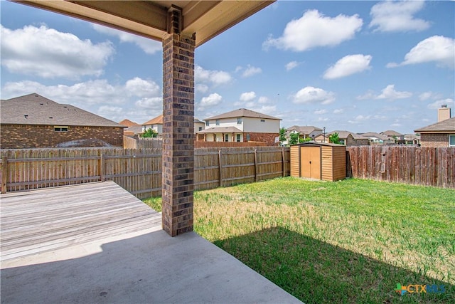 view of yard featuring a storage shed, a patio area, a residential view, and a fenced backyard