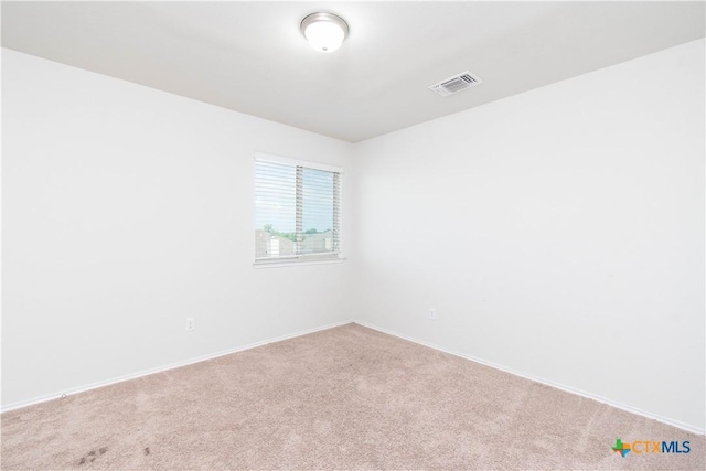 carpeted spare room featuring visible vents and baseboards