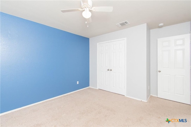 unfurnished bedroom featuring a closet, visible vents, carpet, and baseboards