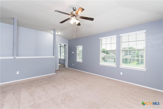 empty room featuring a ceiling fan, baseboards, vaulted ceiling, and carpet floors
